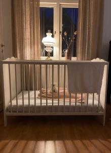 a crib with a stuffed animal in a room with a window at The Photographer's House in Höganäs in Höganäs