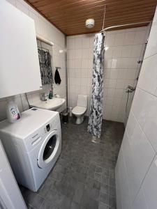 a bathroom with a washing machine and a sink at Studio next to Sello and Leppävaara train station in Espoo