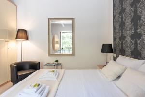 ein Schlafzimmer mit einem Bett mit einem Spiegel und einem Stuhl in der Unterkunft Casa Bramare - YourPlace Abruzzo in Rocca San Giovanni