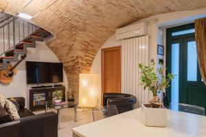 ein Wohnzimmer mit einem Sofa und einem Tisch mit einem TV in der Unterkunft Casa Bramare - YourPlace Abruzzo in Rocca San Giovanni