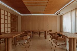 une salle à manger avec des tables et des chaises en bois dans l'établissement Osh Hotel Getsemani, à Carthagène des Indes