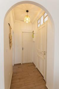 an arched hallway with a door and a chandelier at Luciana Cannes avec parking - proximité centre croisette -gare -plage in Cannes