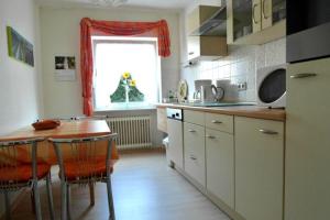 uma cozinha com uma mesa de madeira e uma cozinha com uma janela em Appartement in Urweiler mit Terrasse 