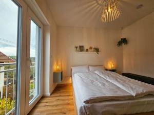 1 dormitorio con cama grande y ventana grande en BETTER modern apartment II Tischkicker I Balkon I Parkplatz en Altusried