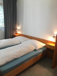 a bed in a bedroom with two lights on at gemütliches neu renoviertes Gästezimmer mit Balkon - b58384 