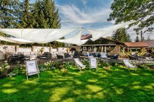 un grupo de sillas de jardín bajo una tienda blanca en Złoty Lin, en Serock