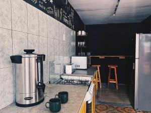 een keuken met een aanrecht met een fornuis en een koelkast bij Palta Hostel in Montevideo