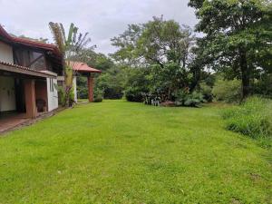 een tuin van een huis met een groen gazon bij Casona los Bambú in San José