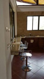 een keuken met 2 stoelen en een aanrecht in een kamer bij Casona los Bambú in San José