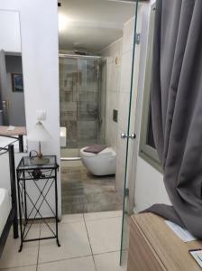 a bathroom with a toilet and a glass shower door at Porto Chania in Chania