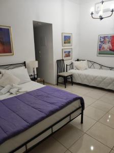 卡尼亞鎮的住宿－Porto Chania，一间卧室配有两张床、一张沙发和一把椅子