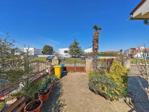 un jardin avec des plantes, une clôture et un palmier dans l'établissement Ferienwohnung für 6 Personen ca 85 qm in Fažana, Istrien Istrische Riviera - b62465, à Fažana