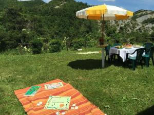 uma mesa com um guarda-chuva na relva em Ferienwohnung für 3 Personen 2 Kinder ca 65 qm in Colombara, Marken Provinz Pesaro-Urbino em Apecchio