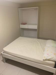 un piccolo letto in una piccola camera con di Otimo apartamento de 02 quartos a Cabo Frio