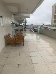 un balcone con sedie e tavoli su un edificio di Otimo apartamento de 02 quartos a Cabo Frio