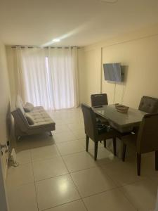 un soggiorno con tavolo e divano di Otimo apartamento de 02 quartos a Cabo Frio