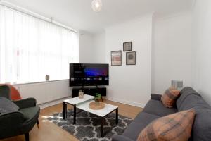 a living room with a couch and a table at Liverpool Haven: Charming Private Room in Liverpool
