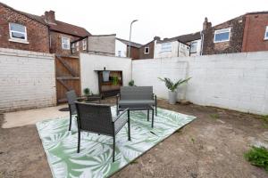 a patio with a table and chairs in a backyard at Liverpool Haven: Charming Private Room in Liverpool