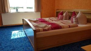 a bedroom with a bed with red and white pillows at Ferienzimmer im Thüringer Wald nahe dem Rennsteig in Siegmundsburg