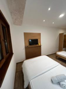 Schlafzimmer mit einem Bett und einem Flachbild-TV in der Unterkunft Apartmani Ristanović Užice in Užice