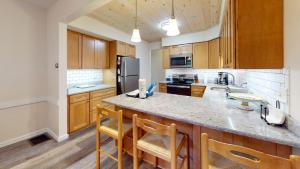 una cocina con armarios de madera y una encimera grande en The Maple Leaf home en Killington