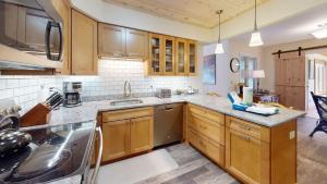 una cocina con armarios de madera y fregadero en The Maple Leaf home en Killington