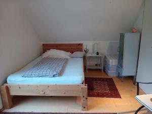 ein Schlafzimmer mit einem Holzbett in einem Zimmer in der Unterkunft Pension Eltmann in Eltmann