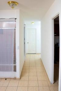 a hallway with a white door and a tile floor at Cozy Two Bedroom Apartment Near The U.S. Embassy in Antiguo Cuscatlán