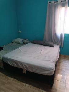 Casa amanhecer 2 في إتابيسيريكا دا سيرا: سرير في غرفة ذات جدار ازرق