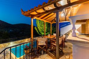 a patio with a table and chairs on a balcony at Avgeri Villa in Skopelos Town