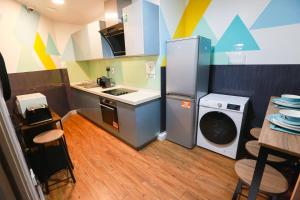 eine kleine Küche mit einem Kühlschrank und einer Waschmaschine in der Unterkunft E104 Urban loft gem in Coventry