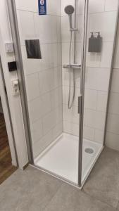 een douche met een glazen deur in de badkamer bij Brandneues Stadtglanz Apartment in Stuttgart