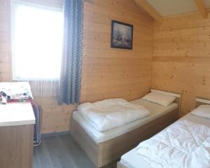 a room with two beds in a wooden cabin at Domki nad morzem Park Jesionów in Pleśna