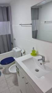 a bathroom with a sink and a toilet and a mirror at T2 Av. 25 de Abril - 2 minutos a pé da praia -Sunny Beach in Costa da Caparica