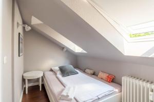 a small attic bedroom with a bed and a skylight at Ferienwohnung Beachside in Strande