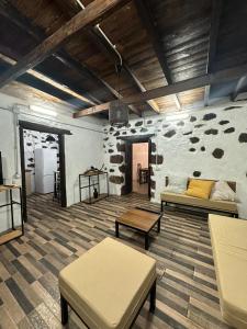 a living room with two couches and a stone wall at Casa Rama San Pedro in San Pedro