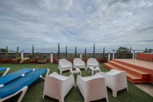un patio con sillas blancas y una tabla de surf azul en Gran Casa Terrera, en Breña Alta