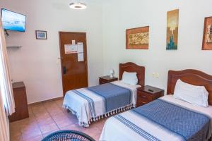 a hotel room with two beds and a tv at Hotel Don Nino in Oaxaca City