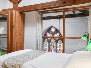 a bedroom with a bed and a stained glass window at Old St Lukes Church in Soulby