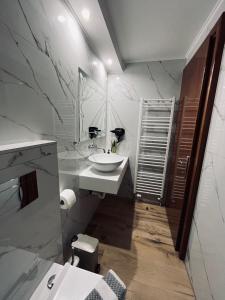 Baño blanco con lavabo y espejo en Paggaio Escape Apartments, en Nikísiani