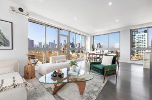a living room with a view of a city at Delancey Tower in New York