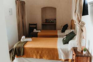 a hotel room with two beds with orange and white sheets at Hostal Africa in Tarifa