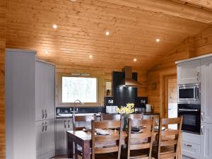 cocina con techo de madera, mesa y sillas en Bank End Lodge, en Carlton