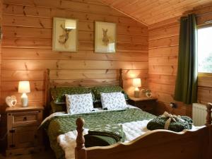 1 dormitorio con 1 cama en una cabaña de madera en Bank End Lodge, en Carlton