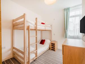a bedroom with two bunk beds and a desk at Pegasus in Falmouth