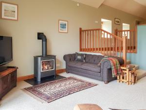 a living room with a couch and a wood stove at Kilduncan Barn in Kingsbarns