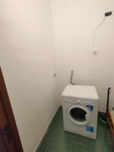 een kleine badkamer met een wasmachine in een kamer bij Affittacamere sunset in Castel Volturno