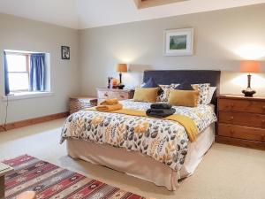 a bedroom with a large bed and a dresser at Kilduncan Barn in Kingsbarns