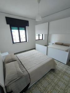 een slaapkamer met een groot bed en een spiegel bij Affittacamere sunset in Castel Volturno