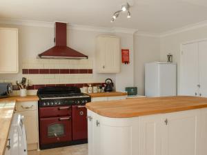 a kitchen with a red stove and a refrigerator at Little Bere in Lifton